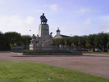 La statue d'Henri Schneider, avec l'église Saint Eugène en arrière plan
